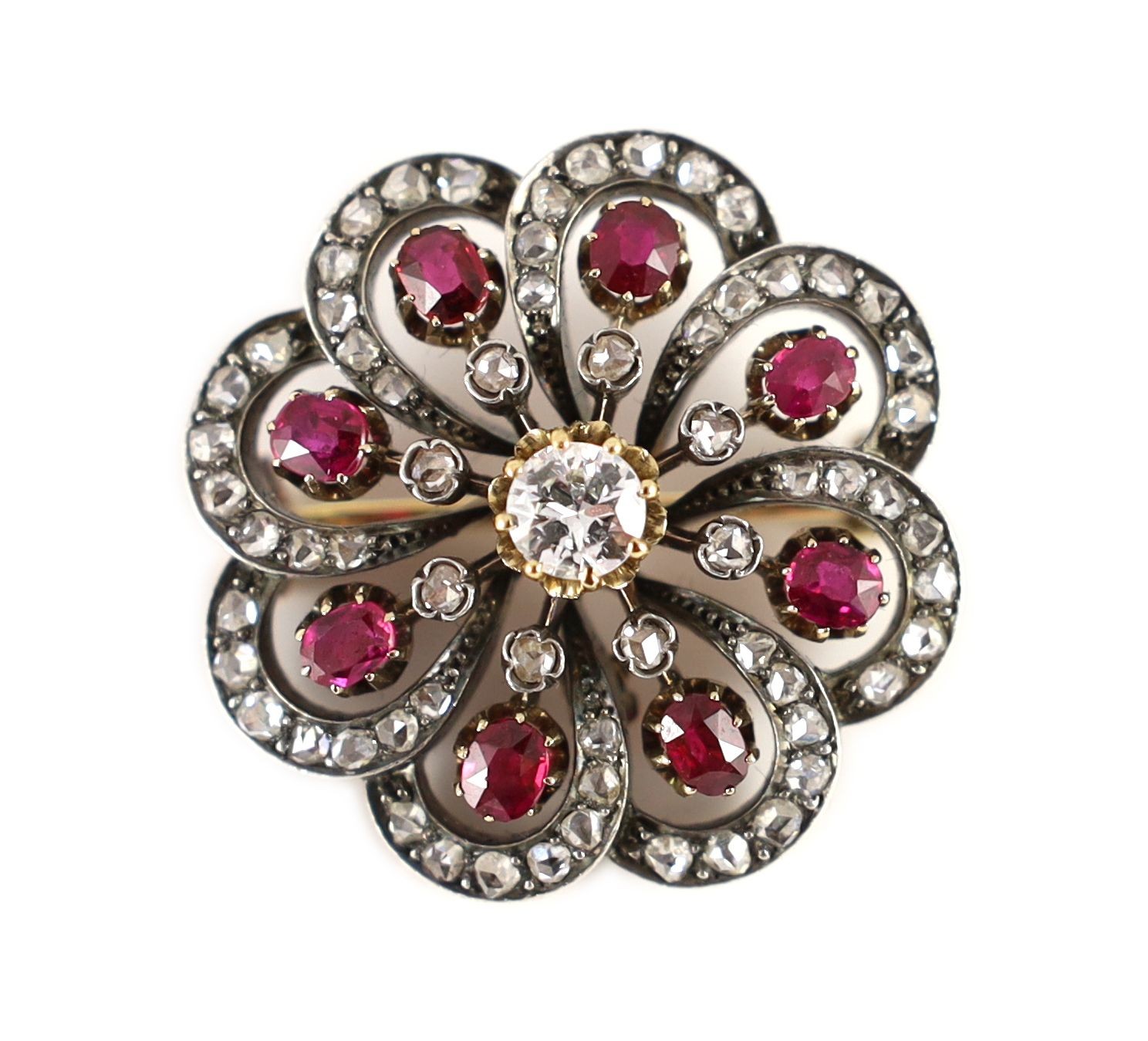 A late Victorian gold and silver, ruby and diamond set whorl shaped brooch